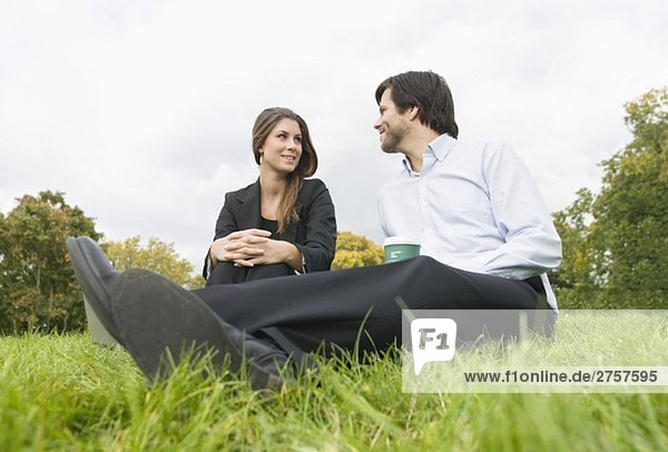 Man and woman sitting on lawn