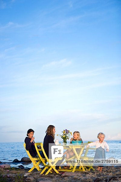 A family having a cup of tea by the ocean Oland Sweden.
