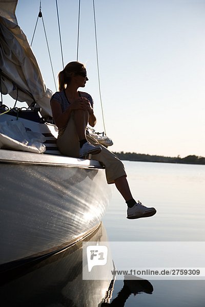 Eine Frau sitzt auf einem Segelboot Östergötlands Schweden.