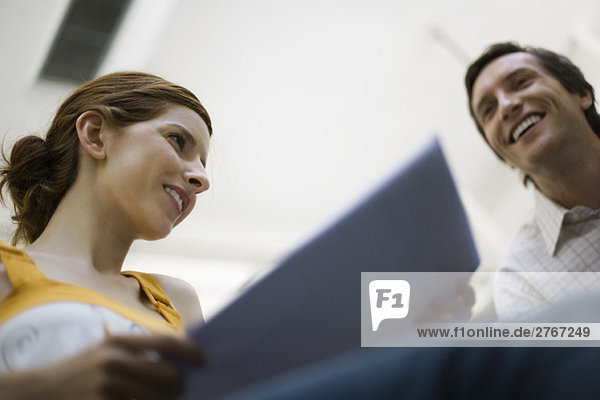 Frau hält Dokument  Mann lächelt in der Nähe  niedriger Blickwinkel