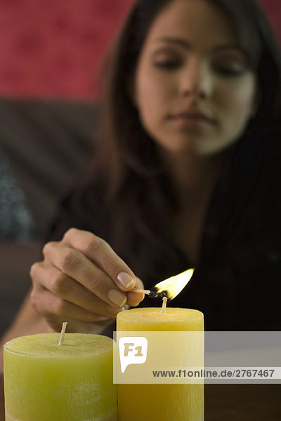 Junge Frau zündet Kerzen an  Fokus auf Vordergrund