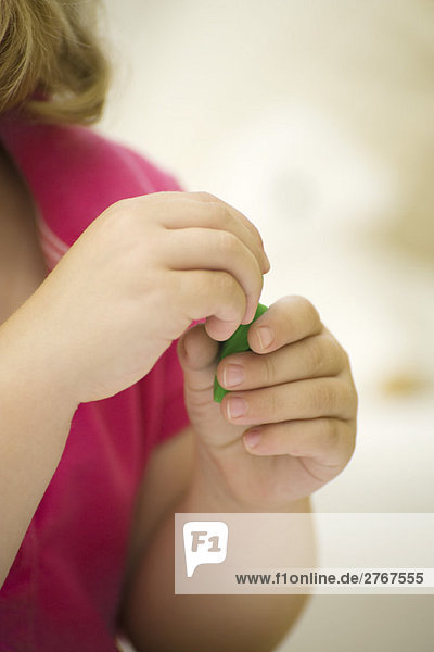 Kinderhände mit grünem Ton