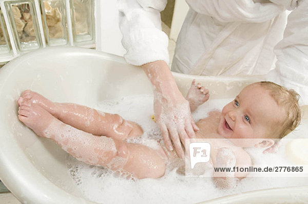 Eine Mutter  die ihren kleinen Jungen badet.