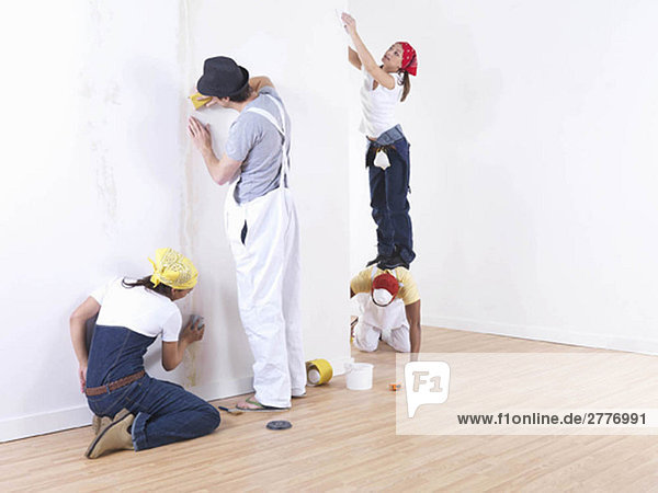 Group of friends sanding wall.