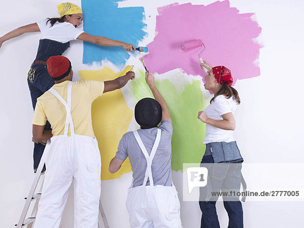 Group of friends painting wall.
