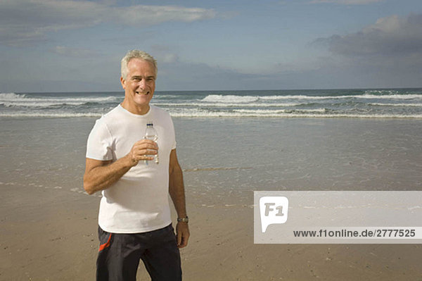 Male drinking water on a beach