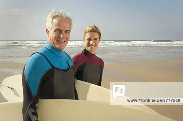 Couple with surfboards on a beach