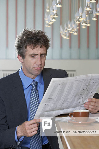 Businessman at bar reading paper  doubt