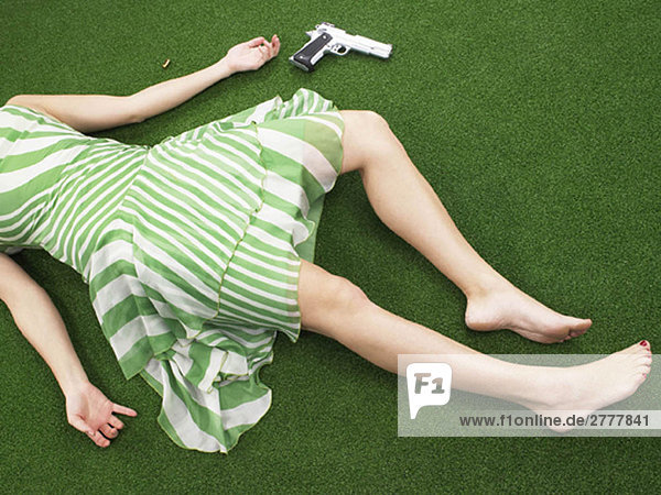Woman lying on floor with gun