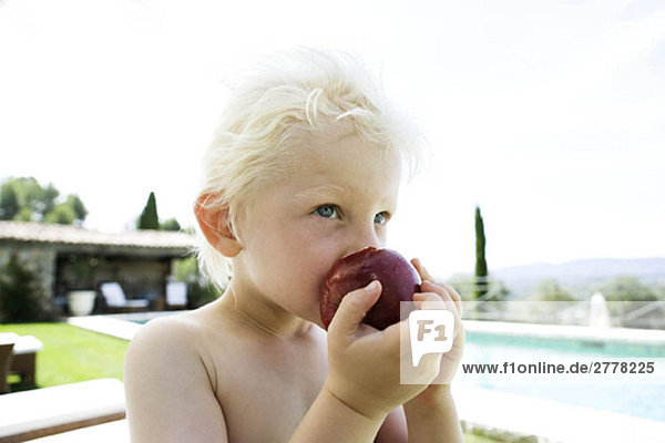 Junge isst einen Apfel