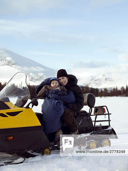 Mother and baby on Snowmobile