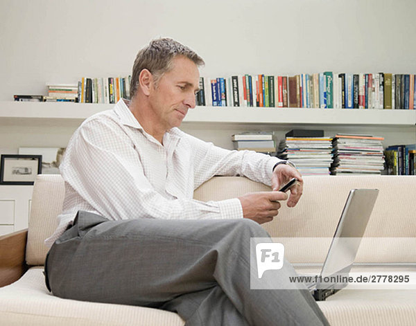 Ein Geschäftsmann sitzt an seinem Laptop.