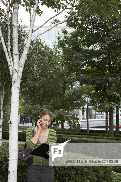 Business woman using mobile outside