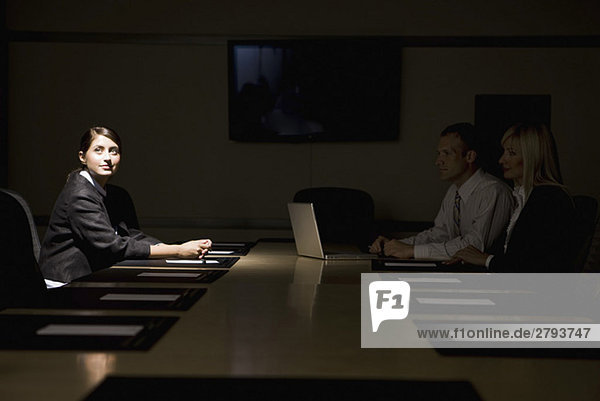 Light shining on Latin American businesswoman in conference room