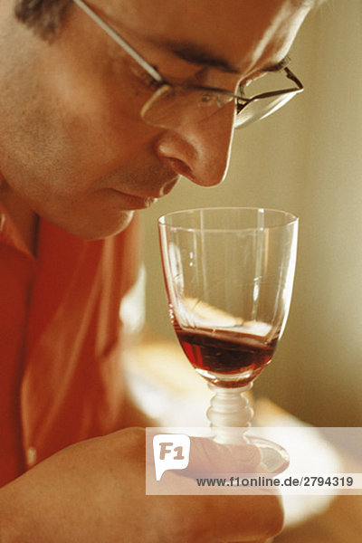 Man smelling red wine in wine glass