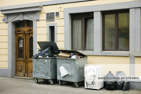 Überquellende Mülltonnen vor dem Gebäude