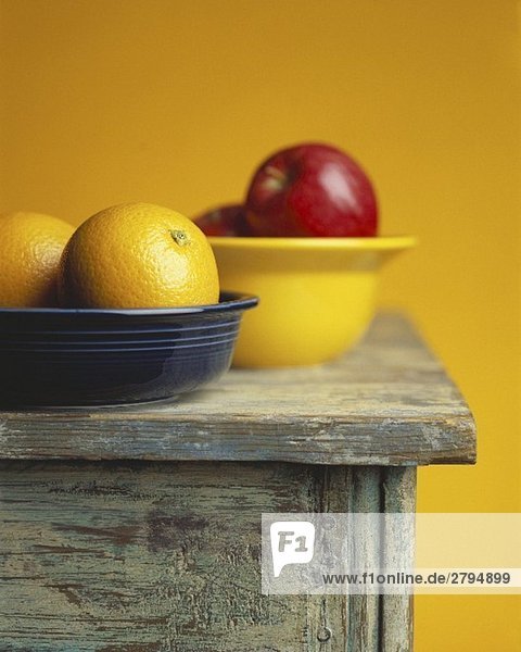 Zwei Ostschalen mit Orangen und Äpfeln auf einem Tisch