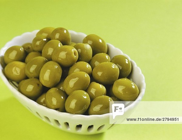 Grüne  in Öl eingelegte Oliven in einem Schälchen