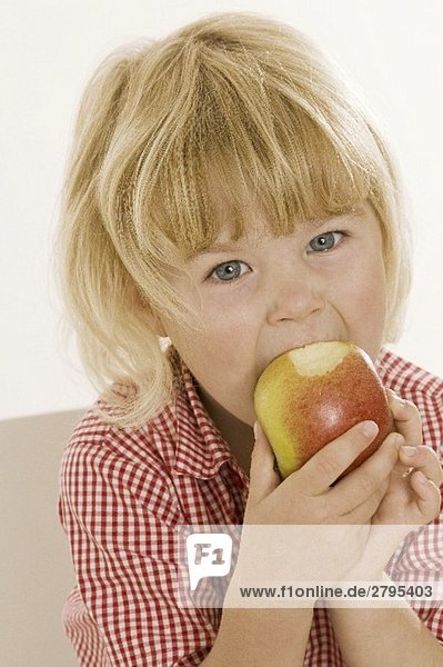 Kleines Mädchen isst einen Bio-Apfel