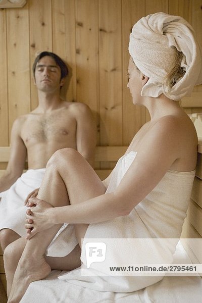 Frau und Mann sitzen in der Sauna