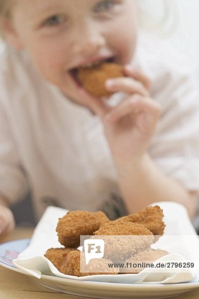 Kleines Mädchen isst Chicken Nuggets