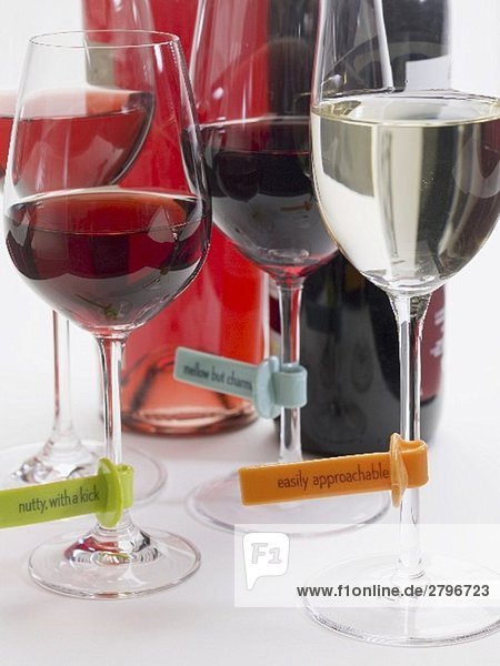 Weingläser mit Plastiketiketten (Weinbeschreibung)  Flaschen