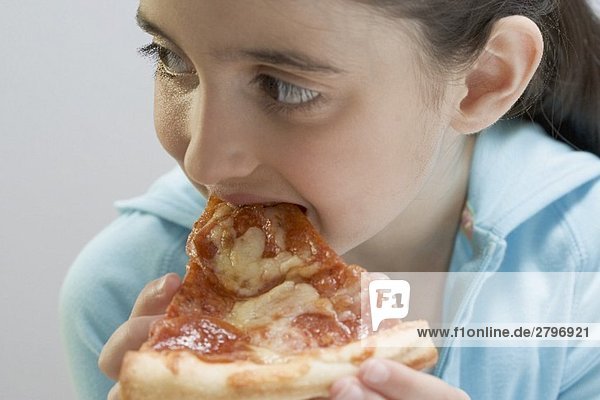Kleines Mädchen isst Stück Pizza