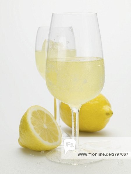Zwei Gläser Limoncello und frische Zitronen