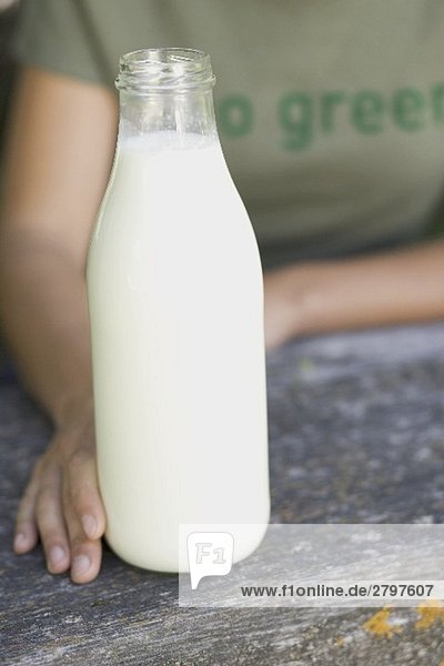 Person holding a bottle of organic milk