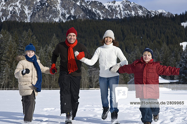 Family enjoying in snow covering landscape