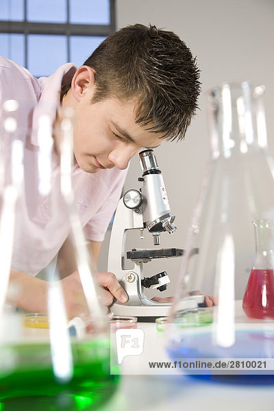Boy suchen durch Mikroskop im Chemielabor