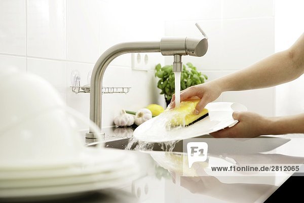 Person waschen Platten in Küche
