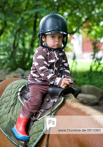 Ein kleiner Junge Schweden eine Pferd Reiten.
