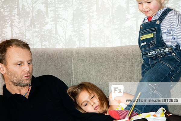 Father son and daughter reading a book Sweden.
