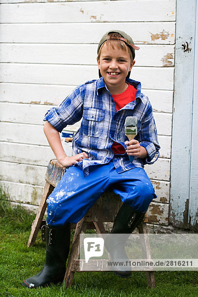 A boy holding a painting brush Sweden.