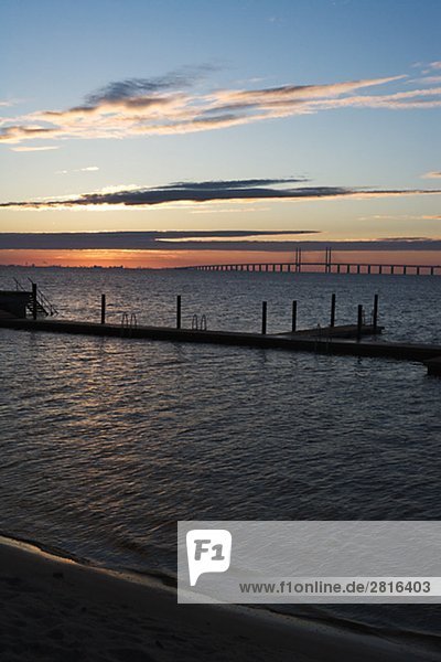 Silhouette von einer Mole mit Oresundsbron im Hintergrund Skane Schweden.