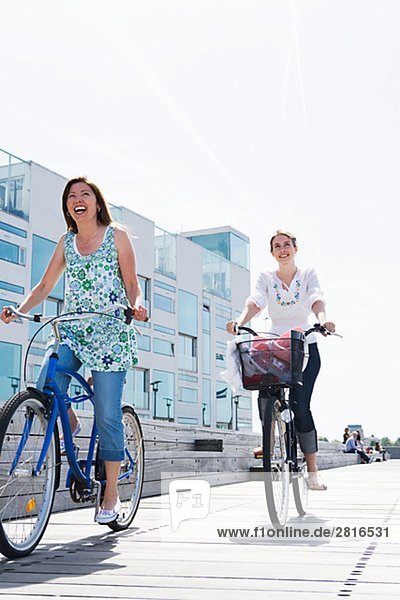 Two women riding bikes Skane Sweden.