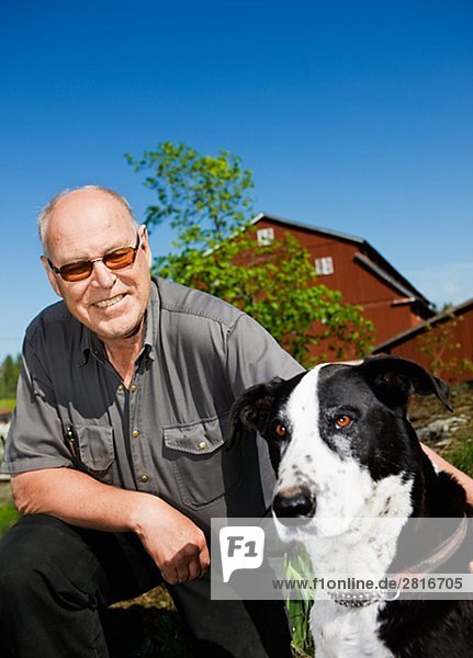 Ein Mann mit einem Hund Schweden spielen.