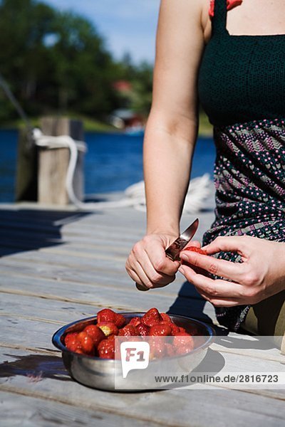Eine Frau mit Erdbeeren am Meer Schweden.