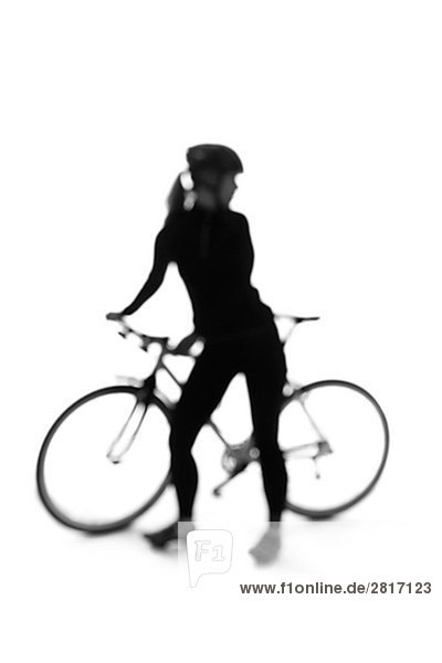 Silhouette einer Frau mit einem Fahrrad.