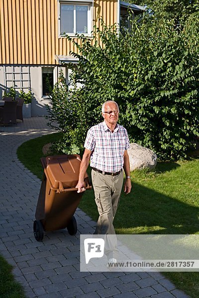 Ein älterer Mann mit einer Mülltonne Schweden.