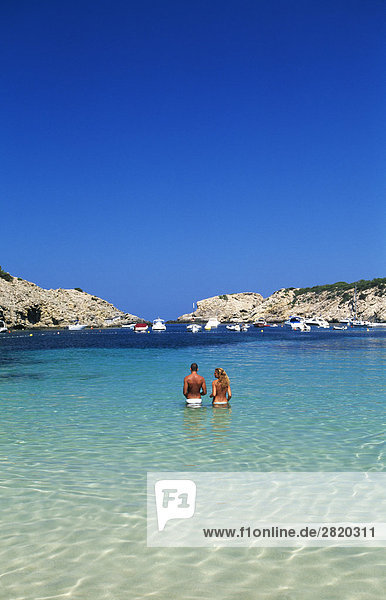 Rückansicht des Paar steht in seichtem Wasser  Cala Moli  Ibiza  Balearen Inseln  Spanien