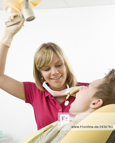 Female dentist examining patient's teeth