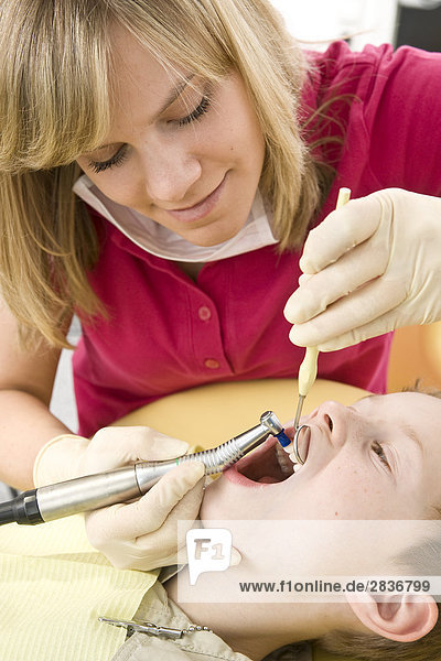 Female dentist examining patient's teeth