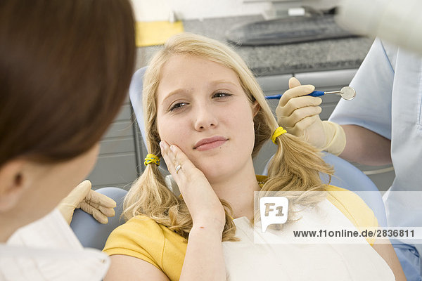 Weiblich Zahnarzt und Assistent examining patient