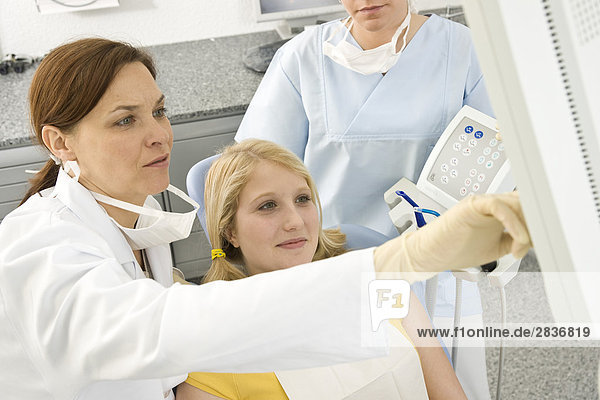 Female dentist and patient looking at monitor