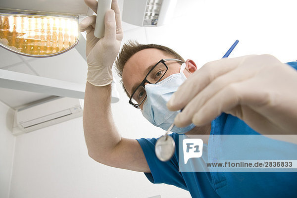 Porträt von männlichen Zahnarzt hält abgewinkelt Spiegel