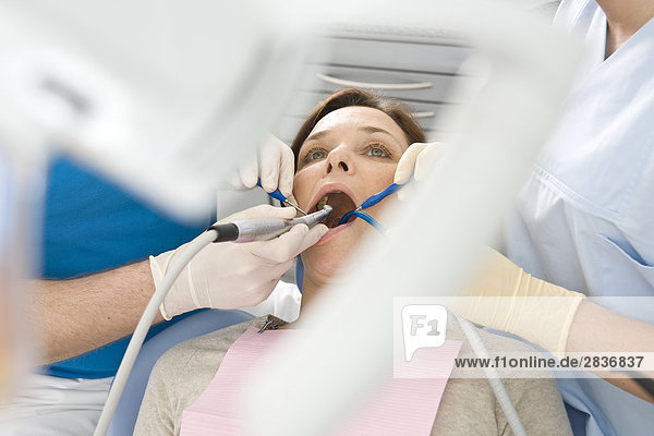 Männlich Zahnarzt und Assistent Untersuchung des Patienten Zähne