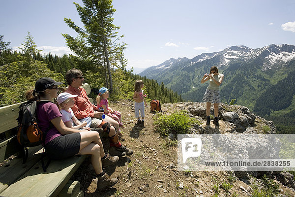 Two families enjoy viewpoint while hiking on trail at Island Lake Resort in the Lizard Range  Fernie  British Columbia  Canada.