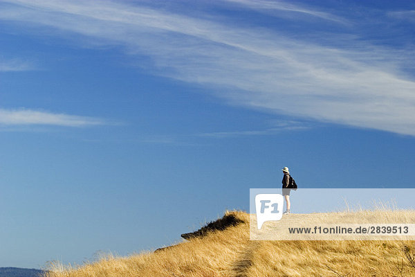 Hiker taking in the view from the East point park on Saturna Island  British Columbia  Canada.